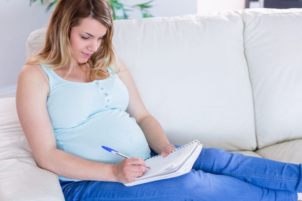 Mujer embarazada escribiendo