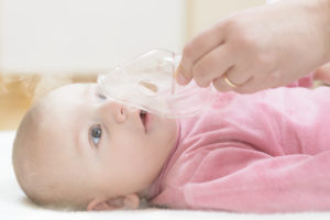 Bebé respirando con un inhalador